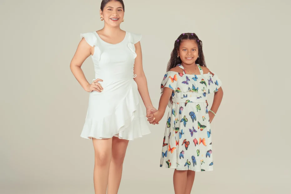 Mujer y niña tomadas de la mano sobre un fondo claro