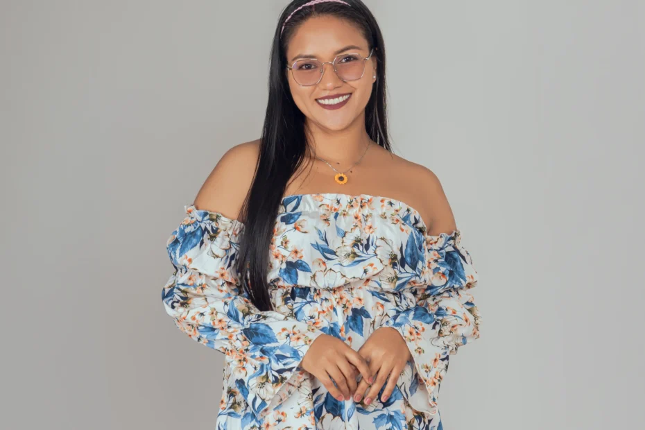 Retrato de una mujer con vestido floral azul sobre fondo claro