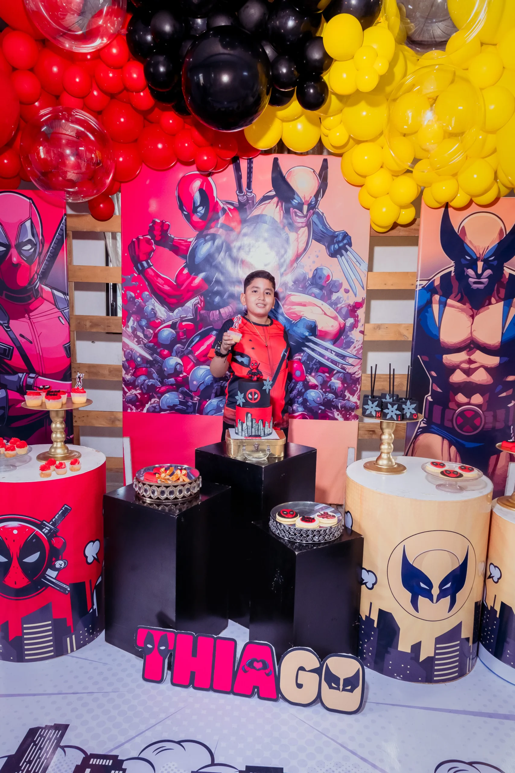 Niña frente a una mesa de cumpleaños y un fondo de globos