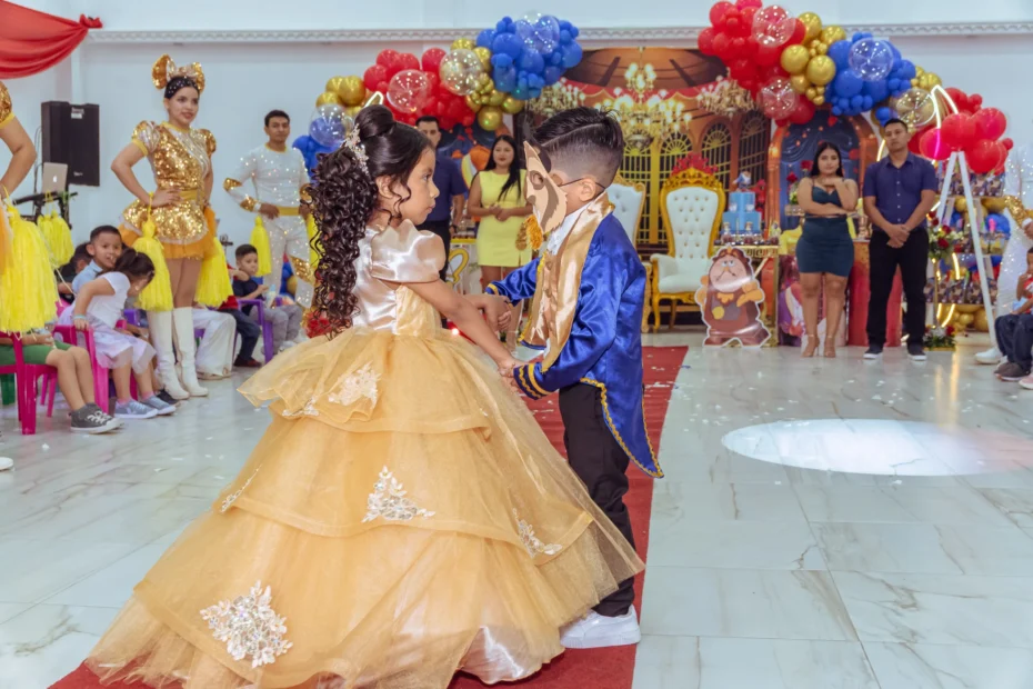 Niña con vestido amarillo junto a un animador durante una celebración
