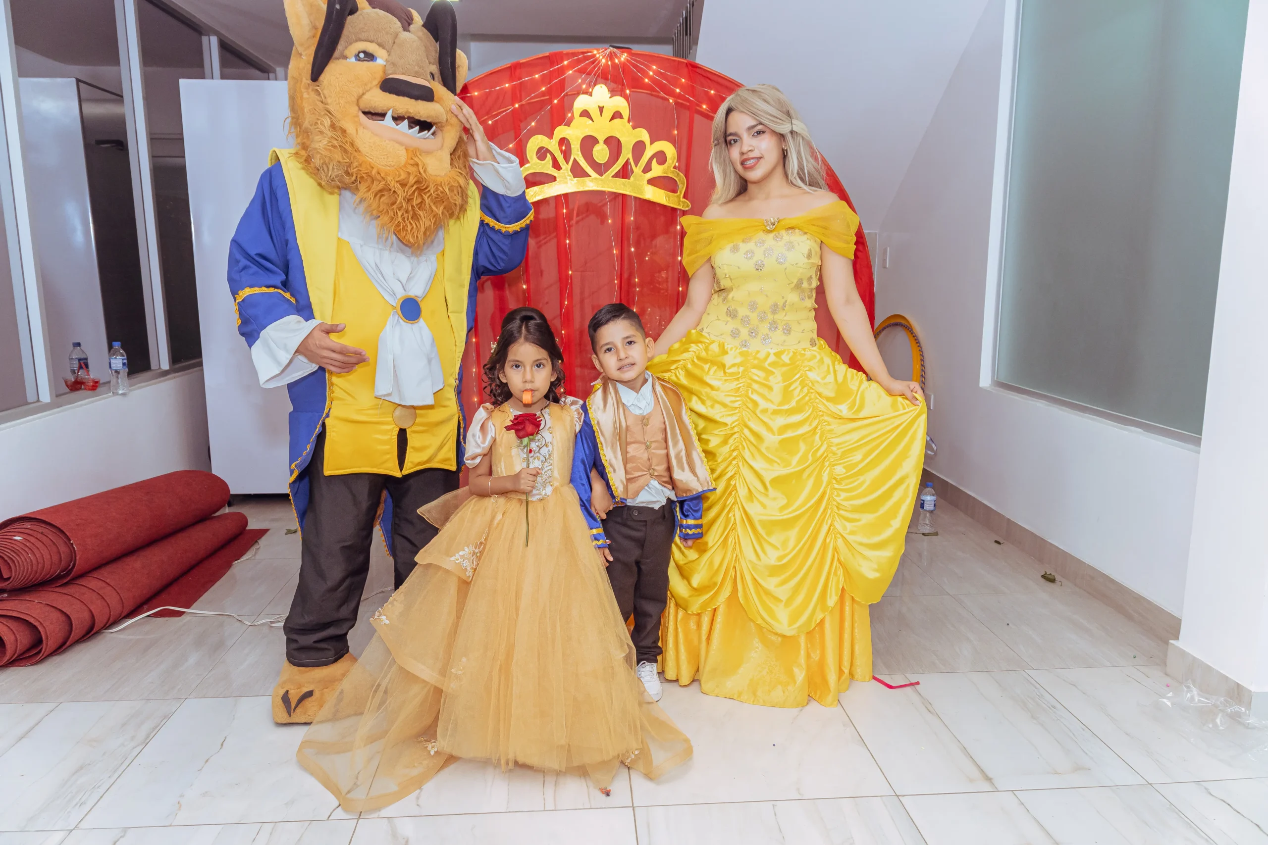 Niña posando entre personajes de La Bella y la Bestia