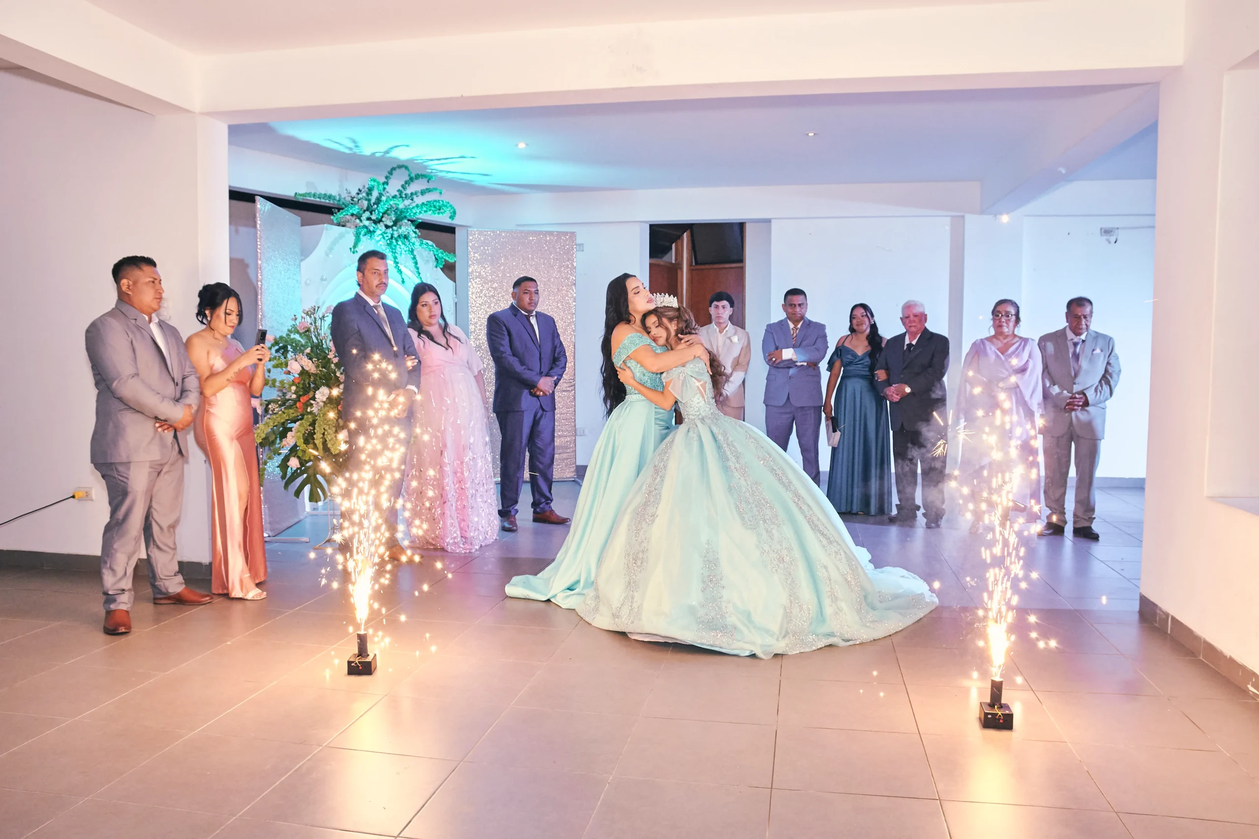 Joven con vestido verde bailando en un salón rodeada de invitados