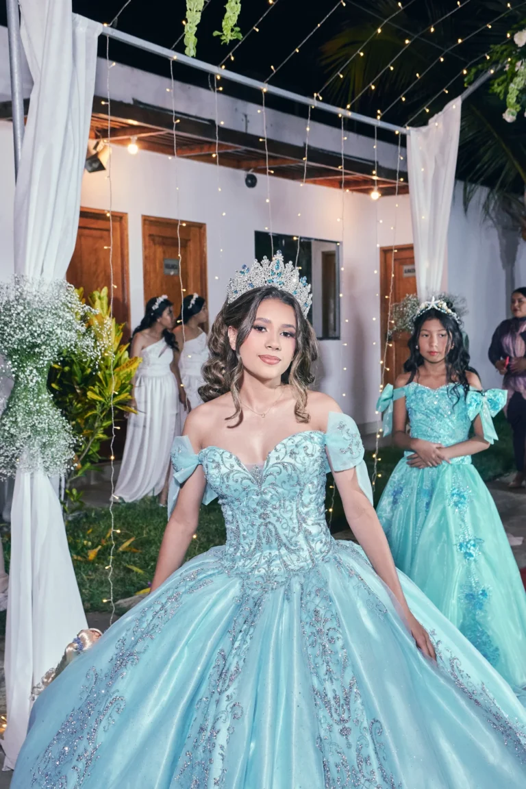 Joven con vestido verde junto a la entrada decorada de su celebración de XV