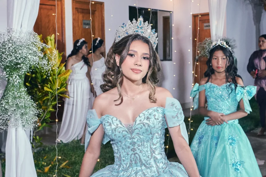 Joven con vestido verde junto a la entrada decorada de su celebración de XV
